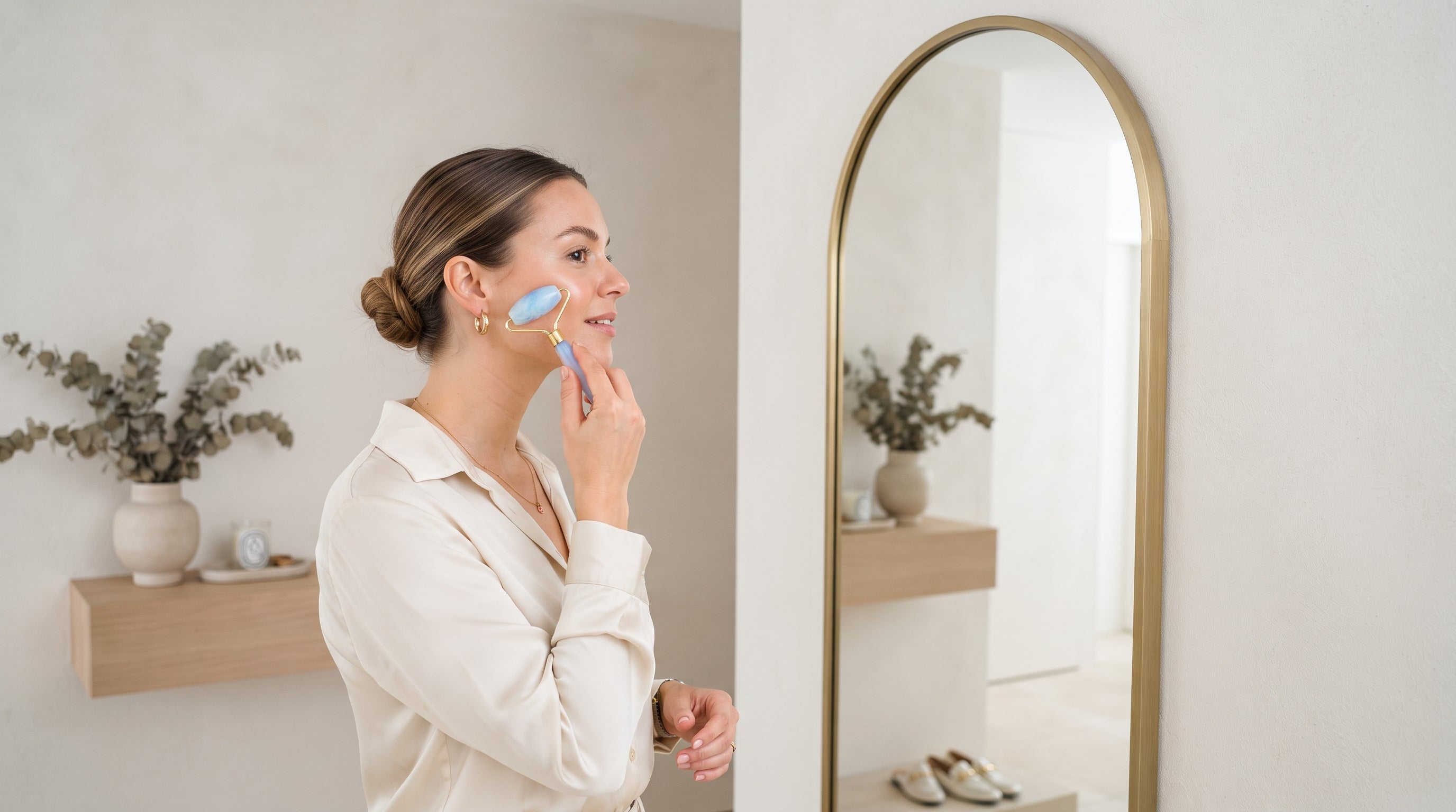 Massage de la joue avec le roller visage Opalya devant un miroir